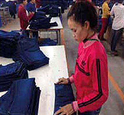 Worker folding and checking finished jeans