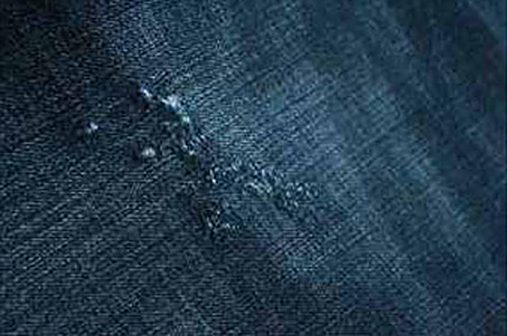 Close-up of dark blue washed denim with light abrasions
